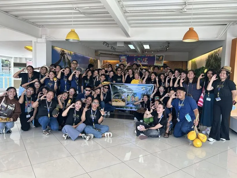 A student group in matching shirts posing together indoors