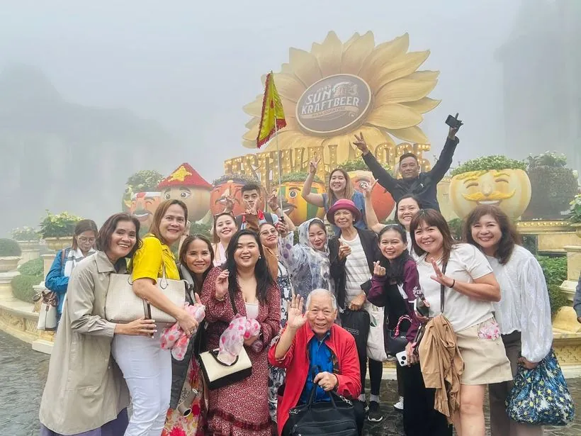 Travellers smiling in the mist at Sun World Ba Na Hills, Da Nang