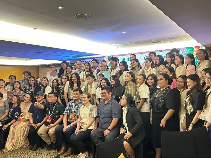 A large delegation in formal wear posing for a group photo
