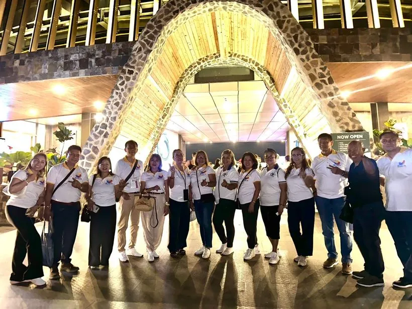 A team in matching white shirts under a lit archway
