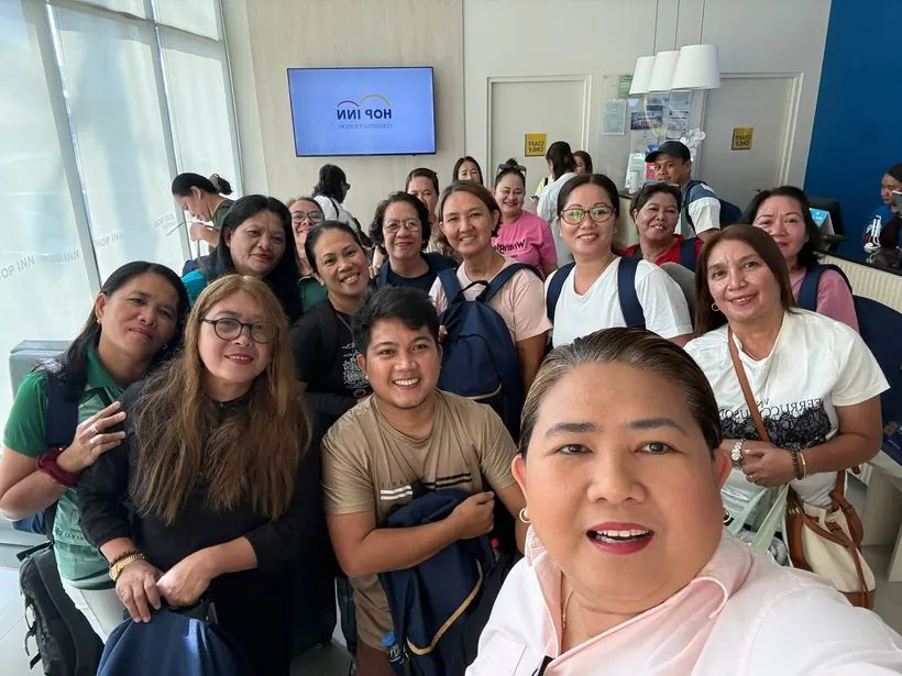 A group selfie in a hotel lobby at check-in