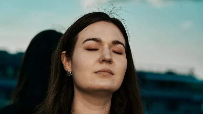 A person with eyes closed, breathing calmly