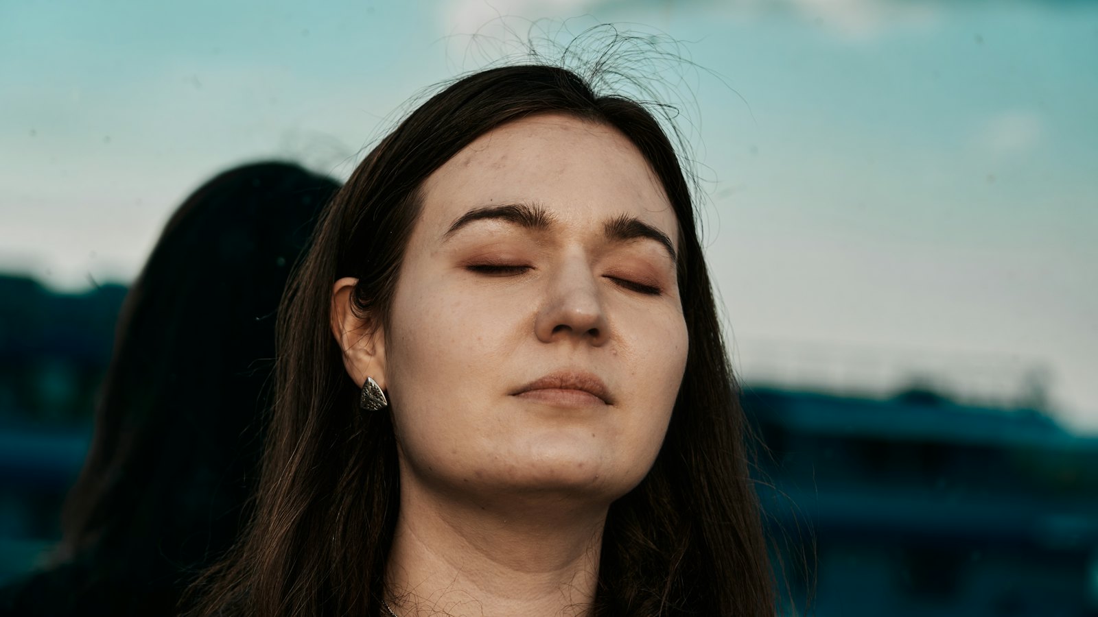 A person with eyes closed, breathing calmly